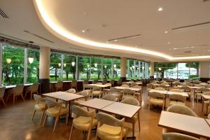 a dining room with tables and chairs and windows at Tokyo Bay Ariake Washington Hotel in Tokyo