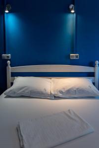 a bed with a blue headboard and a white pillow at AlmaVille Mamaia in Mamaia Sat/Năvodari