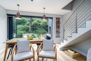 a dining room with a table and chairs and a staircase at Wild Sage - Wilderness Cottage in Wilderness