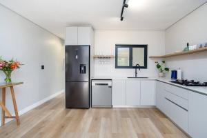 a kitchen with a stainless steel refrigerator in a room at Wild Sage - Wilderness Cottage in Wilderness +12 photos