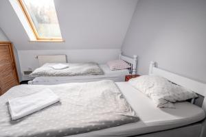 two twin beds in a room with a window at Resort Morawa in Stronie Śląskie