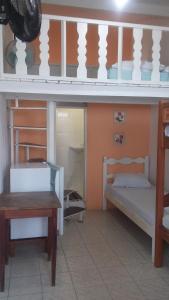 a bedroom with two bunk beds and a table at Hospedagem Casa De Familia in Paraty