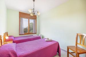 a bedroom with two purple beds and a window at Casa Font Sant Martí de Barcedana in Aransís +17 photos