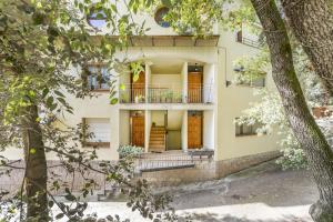 an apartment building with a balcony and trees at Casa Font Sant Martí de Barcedana in Aransís