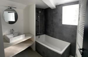 a bathroom with a white tub and a sink at Rooms Buttes Chaumont Chambres Buttes Chaumont in Paris +21 photos