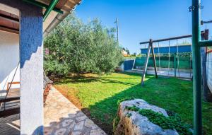 un patio trasero con columpios y un árbol en 1 Bedroom Amazing Apartment In Liznjan, en Ližnjan