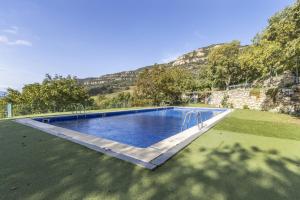 a large swimming pool in a field with a mountain at Jaumet 2 Sant Martí de Barcedana in Aransís