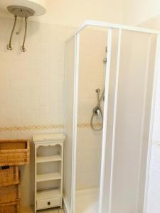 La salle de bains est pourvue d'une douche et d'un placard avec une porte. dans l'établissement San Rocco residence two bed apartments San Rocco 5B2 2, à Isca sullo Ionio