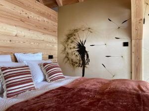 a bedroom with a bed with dandelions on the wall at Les Chalets de Chanteloube "chalets insolites & spa" in Chorges