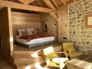 a bedroom with a bed and a stone wall at Les Chalets de Chanteloube "chalets insolites & spa" in Chorges