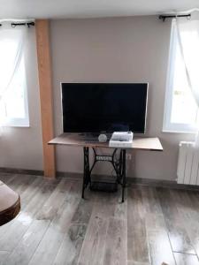 a desk with a computer on it in a room with windows at Maison accueillante à Petit-Caux avec jardin in Tocqueville-sur-Eu