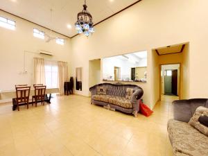 un soggiorno con divani e una sala da pranzo di A'FAMOSA Pool Villa by S&T Homez ad Alor Gajah