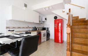 eine Küche mit einem roten Kühlschrank und einem Tisch in der Unterkunft Nice Home In Puerto Rico De Gran Ca in Puerto Rico de Gran Canaria