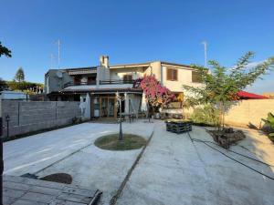 a house with a courtyard in front of it at Nerone's House Villa with garden near the sea, ideal for family in Anzio
