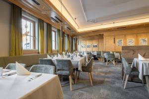 ein Esszimmer mit weißen Tischen und Stühlen in der Unterkunft Hotel Luggi in Galtür