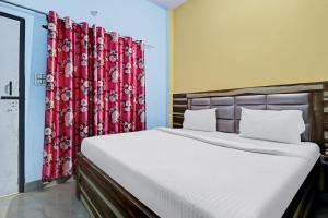 a bedroom with a large bed with red curtains at Hotel O Knight guest house in Morādābād