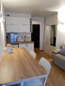 cocina y sala de estar con mesa de madera. en Pretty little flat near from DisneyLand Paris, en Bussy-Saint-Georges 8 fotos más