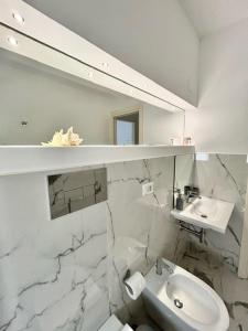 a white bathroom with a sink and a mirror at Aqua Marine B&B - Rooms and Apartments in Milazzo