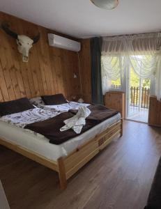 sypialnia z łóżkiem z głową krowy na ścianie w obiekcie Lipics Part w mieście Murarátka