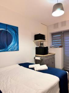 a bedroom with a bed and a microwave in it at Camden Luxury Studio Flats and En-Suit Rooms in London
