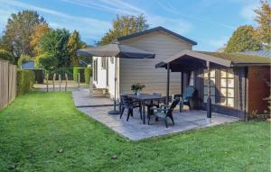 un patio con un tavolo e un ombrellone di Pet Friendly Home In Heinkenszand a heinkenszand Altre 19 foto