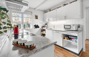a kitchen with white cabinets and a counter top at 3 Bedroom Amazing Home In Væggerløse in Marielyst
