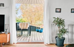 a living room with a door open to a patio at 3 Bedroom Amazing Home In Væggerløse in Marielyst
