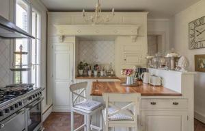 a kitchen with white cabinets and a table and chairs at Stunning Home In Luneray With Wifi in Luneray