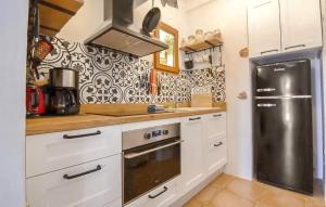 eine Küche mit weißen Schränken und einem schwarzen Kühlschrank in der Unterkunft Casarena in Cala d´Or + 13 Fotos