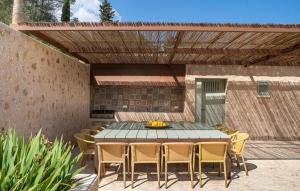 a patio with a table and chairs under a pergola at Can Guillem-Bet in Pollença