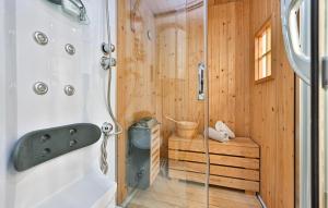 a shower in a wooden bathroom with a sink at Gorgeous Home In Gornja Voca With Sauna in Gornja Voća