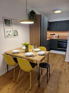 a dining room table with yellow chairs in a kitchen at Apartmán Ski & Bike Janské Lázně in Janske Lazne