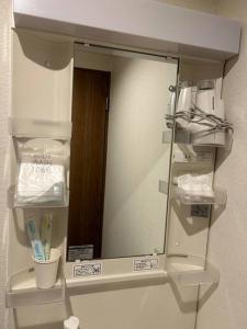 einen Spiegel an der Wand im Bad in der Unterkunft 京橋駅徒歩10分圏内隠れ宿京橋 in Osaka