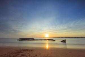 a pier in the water with the sunset in the background at Évasion bord de mer Studio à 50m de la plage in Saint-Brevin-les-Pins
