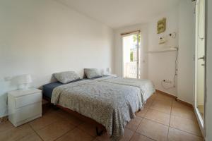 a white bedroom with a bed and a window at Apartment happy place mit Meerblick in Alcalá