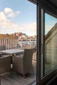a balcony with a table and chairs and a window at Alizee - fam penthouse - 3 parkings in Knokke-Heist