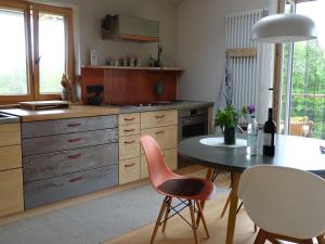 a kitchen with a table and two chairs at Ferienwohnung Bei der Töpferei in Pittenhart +19 photos