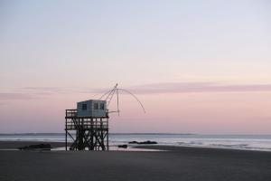 a lifeguard tower on the beach at sunset at Évasion bord de mer Studio à 50m de la plage in Saint-Brevin-les-Pins
