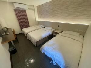 a room with two beds in a hotel room at Yung An Business Hotel in Dounan