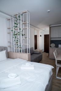 Un dormitorio con una cama blanca y una sala de estar. en Residence Hill A036 Apartment, en Kopaonik 47 fotos más