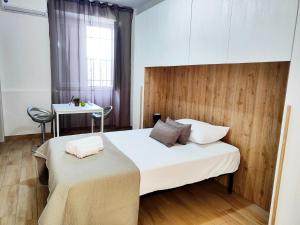 a bedroom with a large white bed and a table at Cientopera in Pontecagnano +104 photos