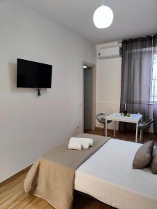 a bedroom with a bed with a flat screen tv on the wall at Cientopera in Pontecagnano
