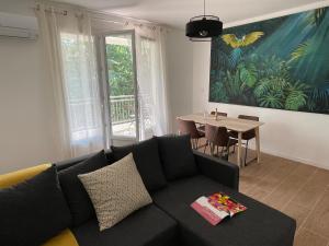 Le Nid D'Aiguelongue Parking Wifi Climatisation Terrasse في مونبلييه: غرفة معيشة مع أريكة وطاولة