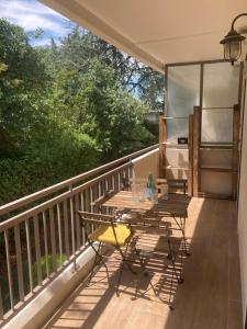 Le Nid D'Aiguelongue Parking Wifi Climatisation Terrasse في مونبلييه: طاولة على شرفة مطلة على الأشجار