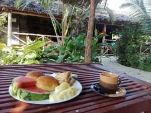 a plate of food and a cup of coffee on a table at SHADRACK BackPackers in Nungwi