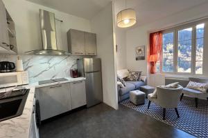 a kitchen and living room with a refrigerator and a couch at Le jardin privatif de Pauze Cauterets wifi et parking gratuits Vue panoramique in Cauterets +22 photos