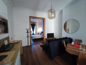 a living room with a black couch and a mirror at Le Liégeois - proche centre - Maison de maître in Liège