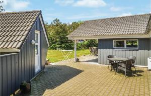 a small house with a table and a patio at Holiday Home Møllevangen Oksbøl X in Ovtrup