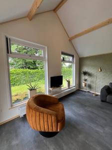 Campingpark de Linie في Opheusden: غرفة معيشة مع كرسي وتلفزيون +62 صورة