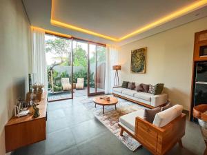 a living room with a couch and a table at Villa Suarga Des Anicca in Ubud